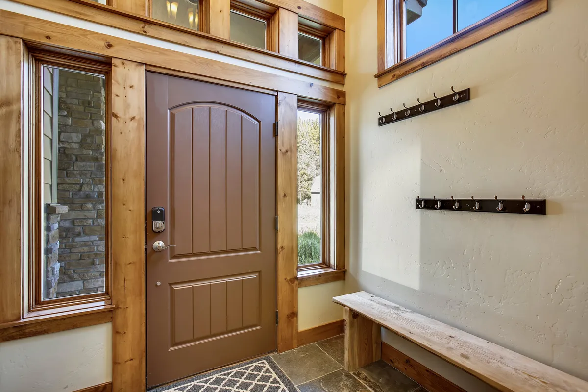 A welcoming entryway featuring a front door, windows, coat hooks, and a bench. The area is inviting and functional—perfect for transitioning between outdoor adventures and indoor comfort.
